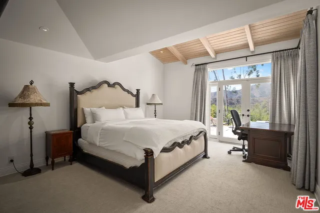 a spacious bedroom with a bed and a large window