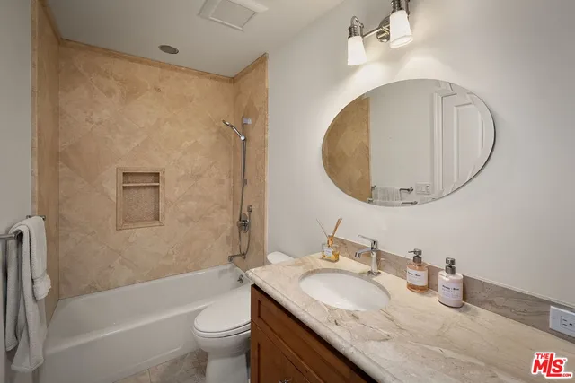 a bathroom with a granite countertop sink a toilet and a mirror