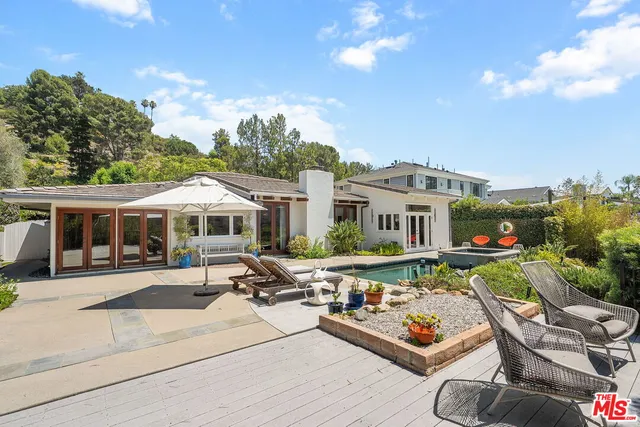 a front view of a house with garden and seating area
