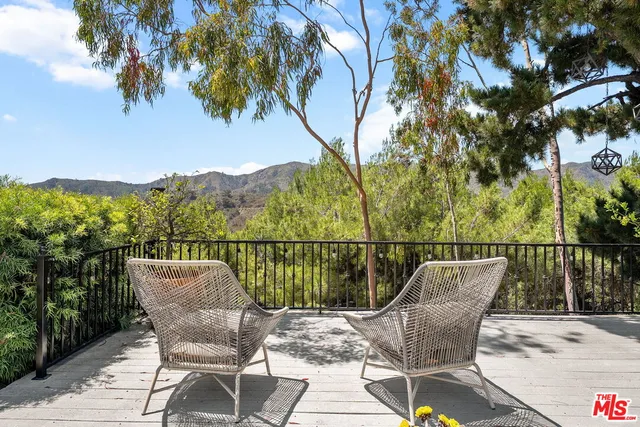 a view of a balcony with two chairs and a table