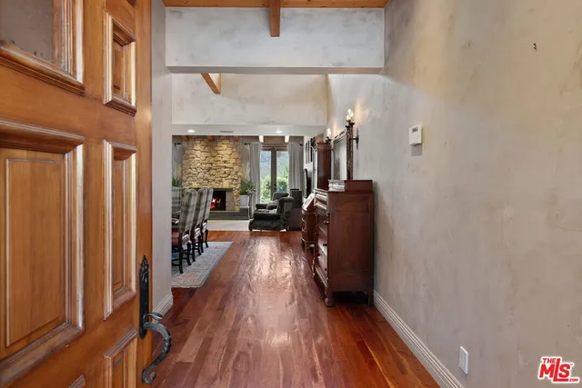 a view of a hallway with wooden floor and furniture