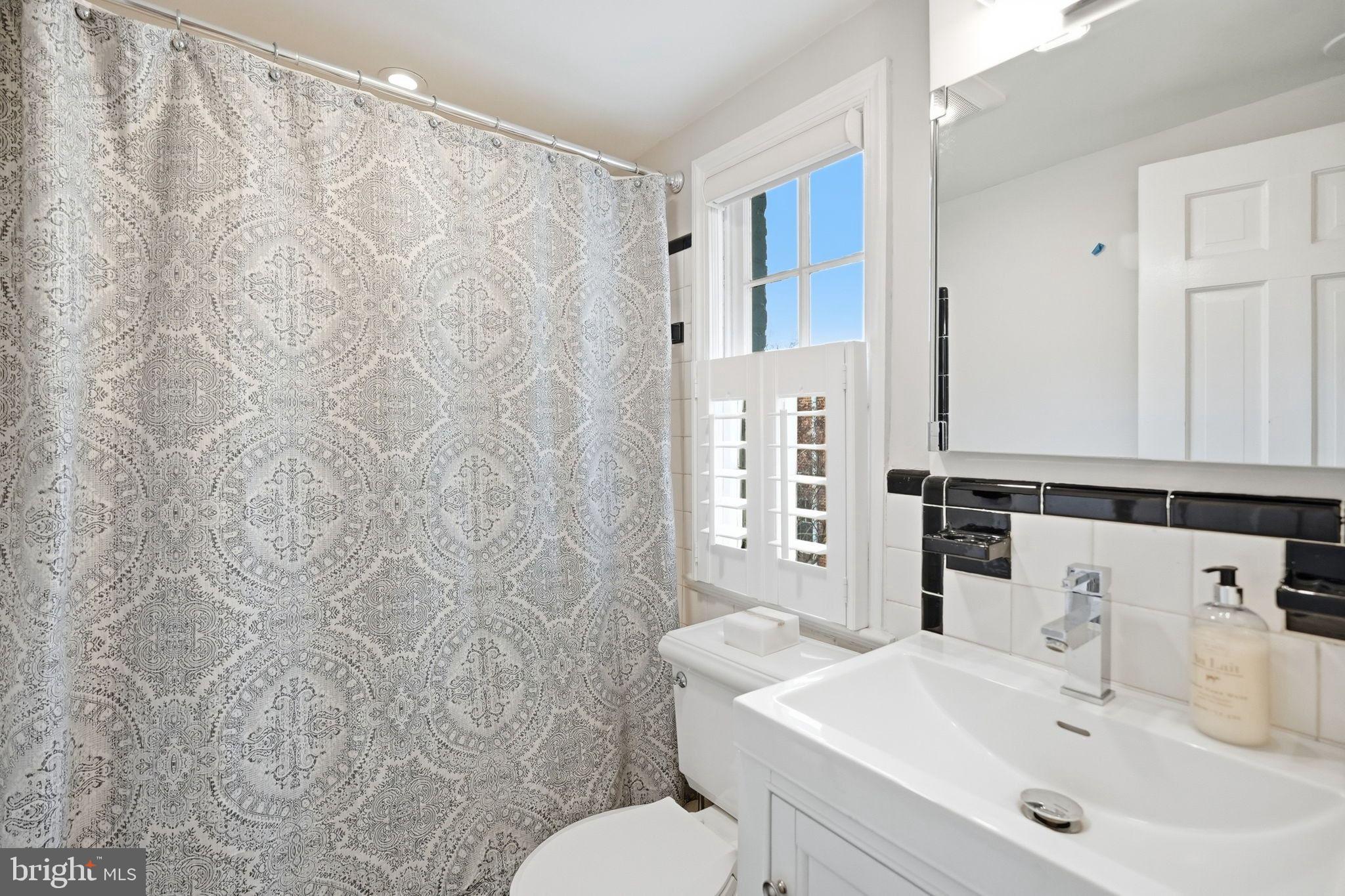 2708 P Street Northwest Washington, DC 20007 - Photo 21 of 35 a bathroom with a sink mirror and a toilet