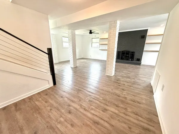 a view of empty room with wooden floor and fireplace