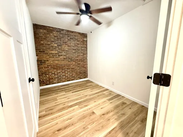 a view of a hallway with wooden floor and staircase