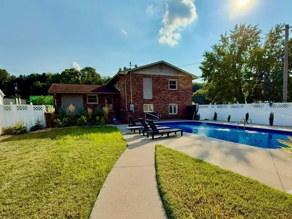 a view of a house with swimming pool and sitting area