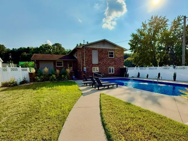 a view of a house with swimming pool and sitting area
