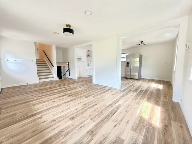 a view of a bedroom with wooden floor and stairs
