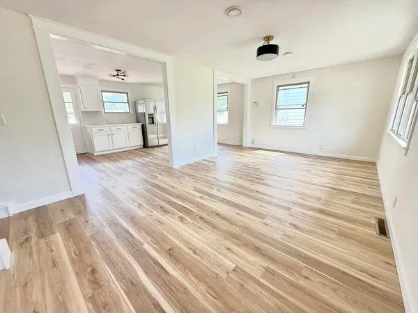 a view of a bedroom with wooden floor and windows