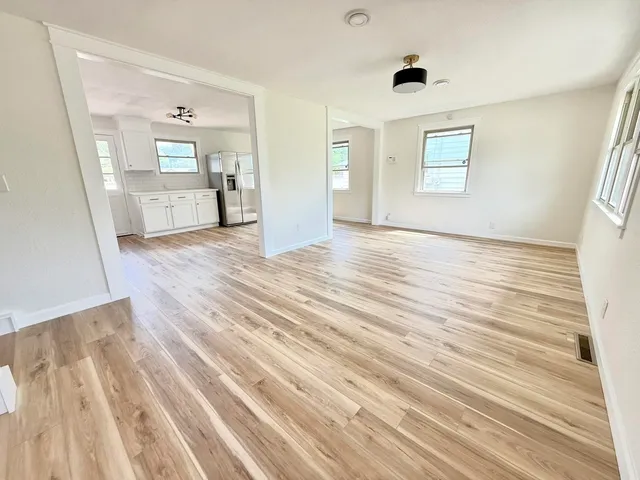 a view of a bedroom with wooden floor and windows