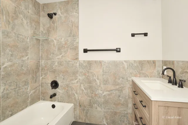 a bathroom with a tub sink and mirror
