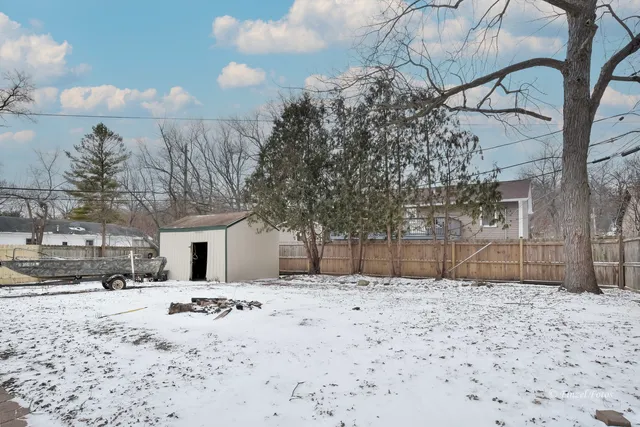 a view of a yard covered with snow in front of house