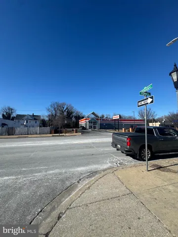 a living room with stainless steel appliances furniture a rug and a large window