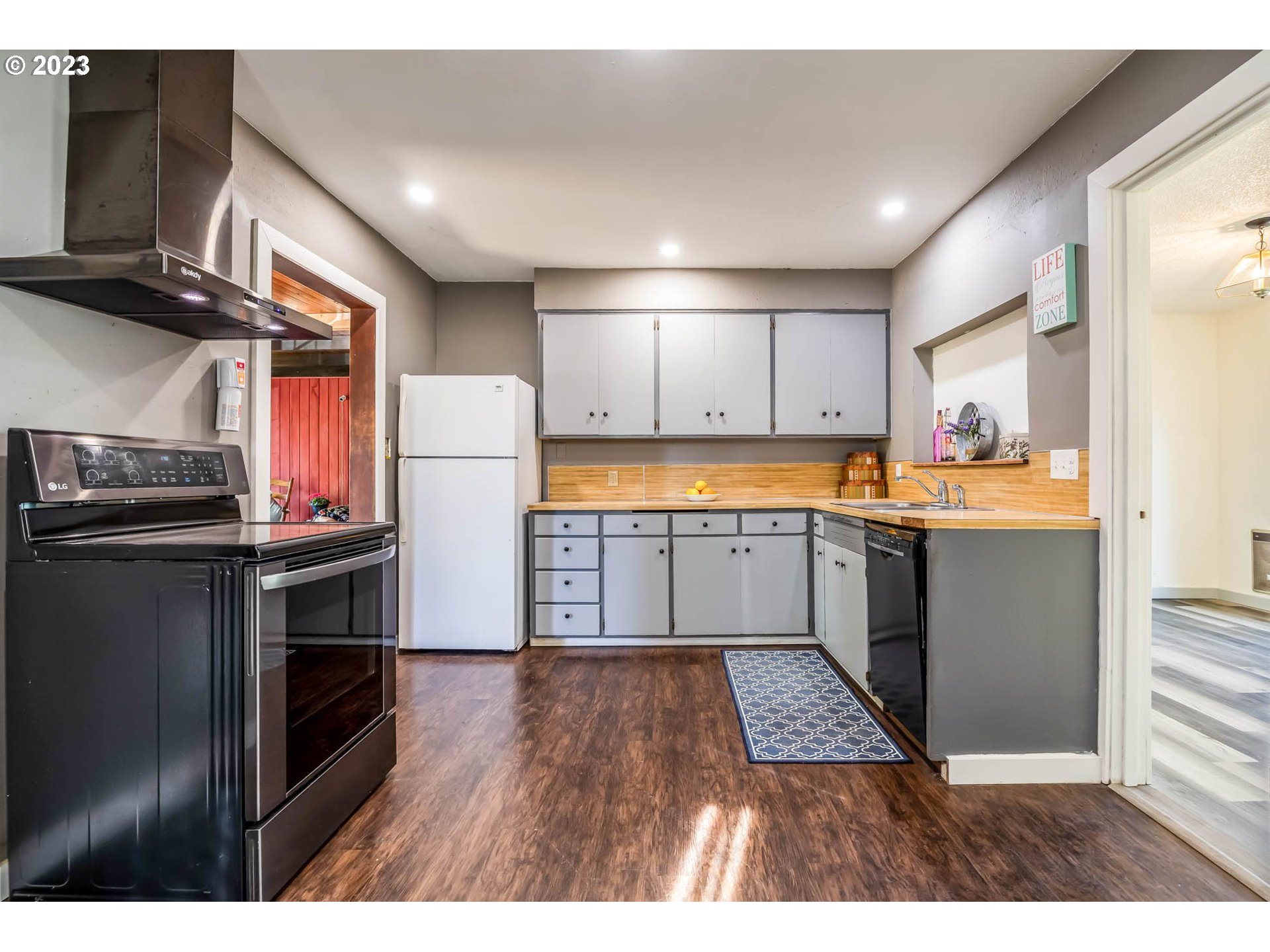 1565 Laura Street Springfield, OR 97477 - Photo 13 of 40 a kitchen with stainless steel appliances granite countertop a refrigerator a sink dishwasher a stove with wooden floor