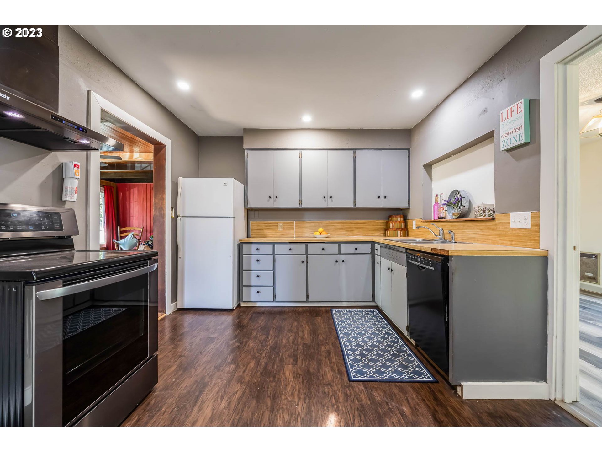 1565 Laura Street Springfield, OR 97477 - Photo 14 of 40 a kitchen with stainless steel appliances kitchen island wooden cabinets a stove a sink and a refrigerator