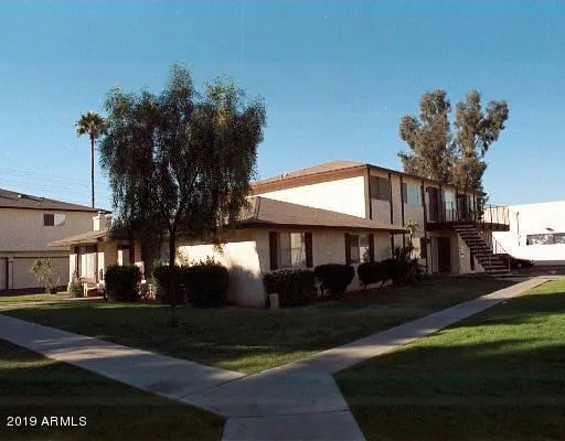 a front view of a house with a yard and potted plants