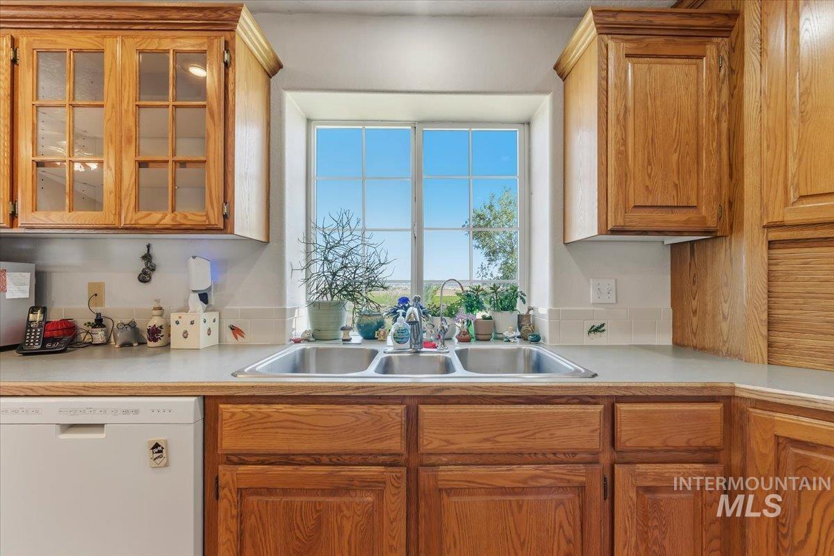 2331 Gulley Road Homedale, ID 83628 - Photo 14 of 46 Kitchen featuring a double basin stainless steel sink, light-toned countertops, and wood cabinetry throughout