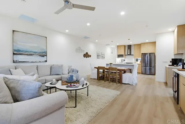 a living room with furniture kitchen view and a refrigerator