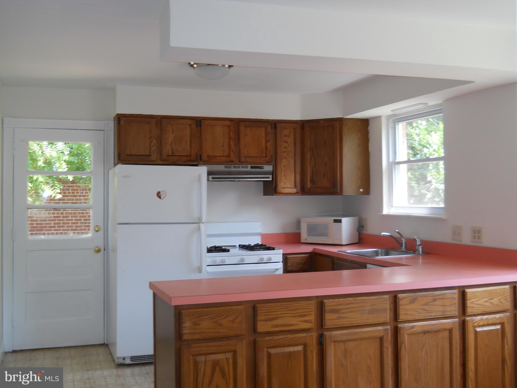 12607 Dean Road Silver Spring, MD 20906 - Photo 8 of 34 a kitchen with a sink cabinets and window