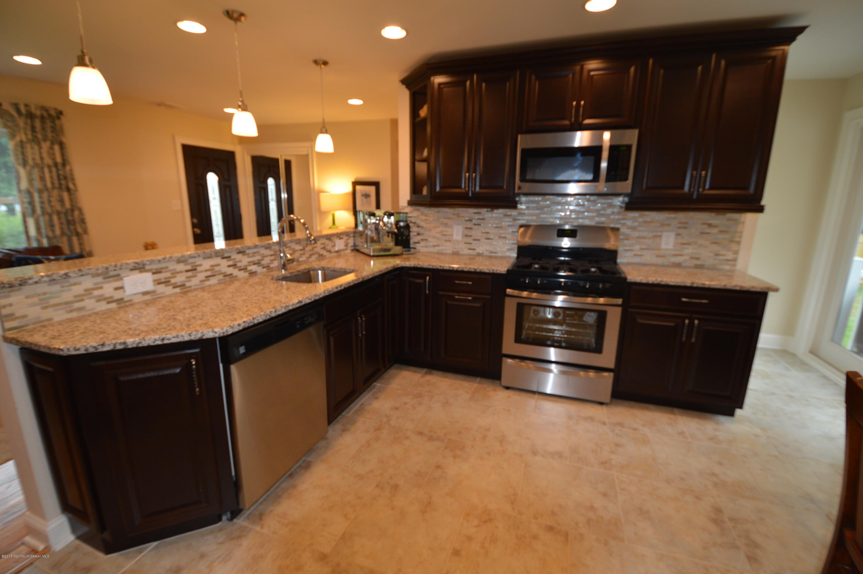 260 Adelphia Road Farmingdale, NJ 07727 - Photo 12 of 30 a kitchen with stainless steel appliances granite countertop a stove a sink and a microwave