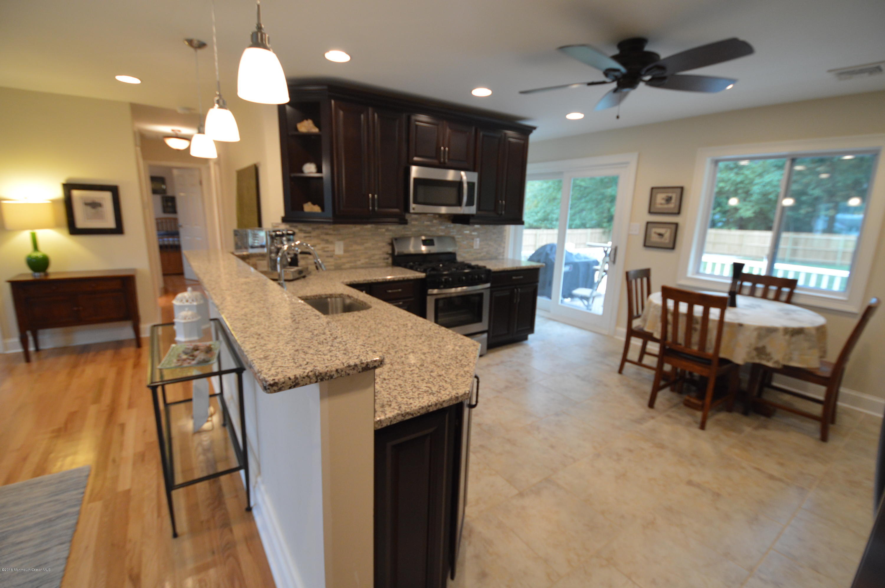 260 Adelphia Road Farmingdale, NJ 07727 - Photo 9 of 30 a kitchen with stainless steel appliances granite countertop sink stove refrigerator dining table and chairs