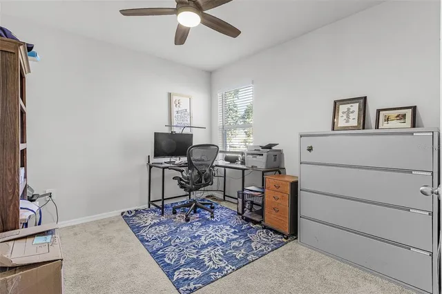 a view of a workspace with furniture and a window