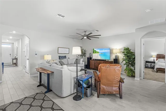 a living room with a couch and a dining table with wooden floor
