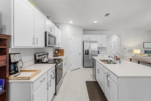 a kitchen with a sink a stove and cabinets