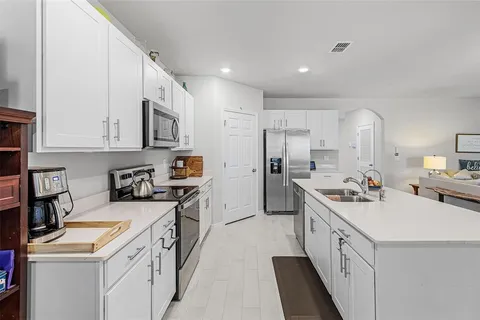 a kitchen with a sink a stove and cabinets