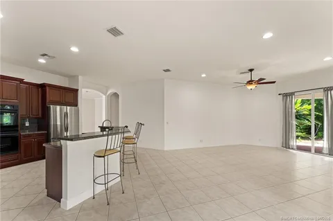 a view of an empty room with wooden floor and a chandelier