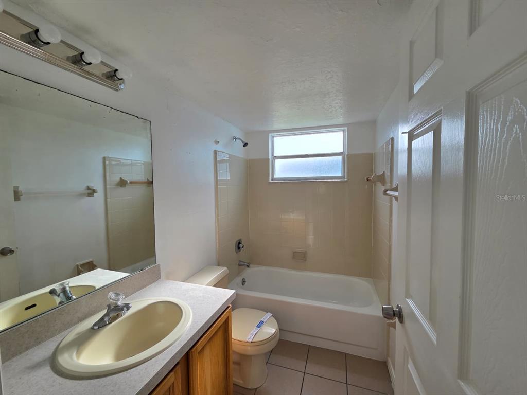 2751 North Poinciana Boulevard, Unit 27 Kissimmee, FL 34746 - Photo 14 of 18 a bathroom with a sink a toilet and a mirror