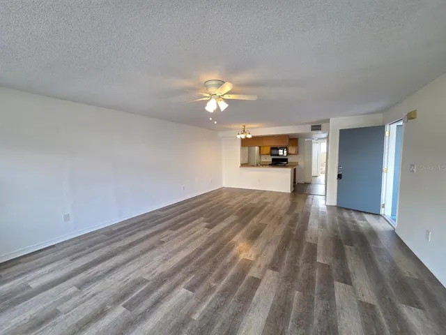 a view of an empty room and window and wooden floor