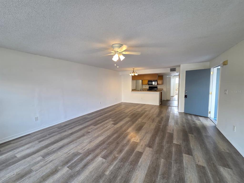 2751 North Poinciana Boulevard, Unit 27 Kissimmee, FL 34746 - Photo 3 of 18 a view of an empty room and window and wooden floor