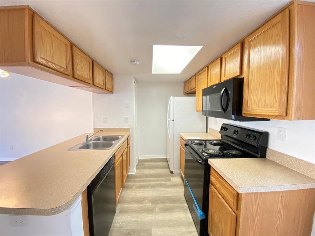 2751 North Poinciana Boulevard, Unit 27 Kissimmee, FL 34746 - Photo 6 of 18 a kitchen with stainless steel appliances granite countertop a sink stove and refrigerator
