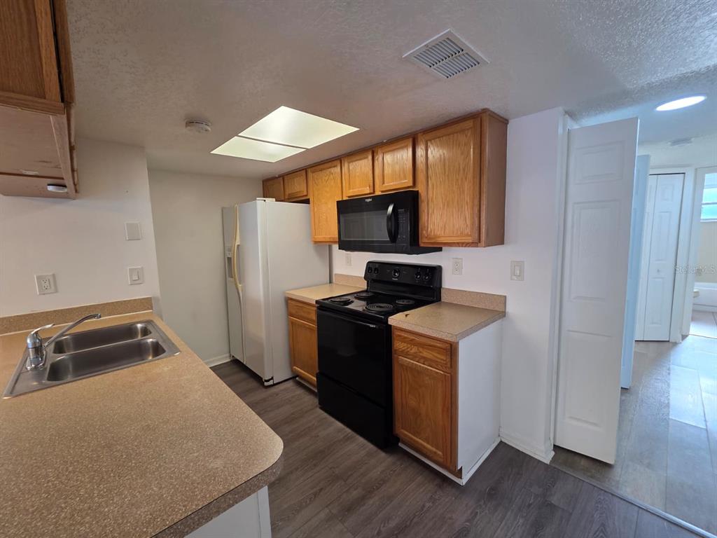 2751 North Poinciana Boulevard, Unit 27 Kissimmee, FL 34746 - Photo 7 of 18 a kitchen with a stove and a refrigerator