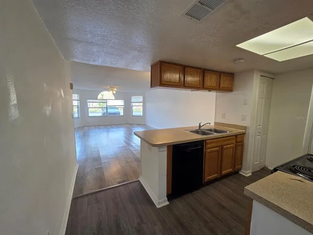 a kitchen with stainless steel appliances granite countertop a stove and a wooden floors