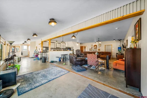 a living room with lots of furniture and kitchen view