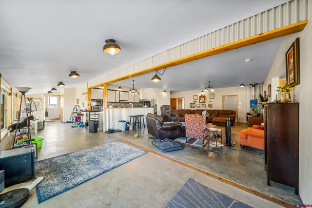a living room with lots of furniture and kitchen view