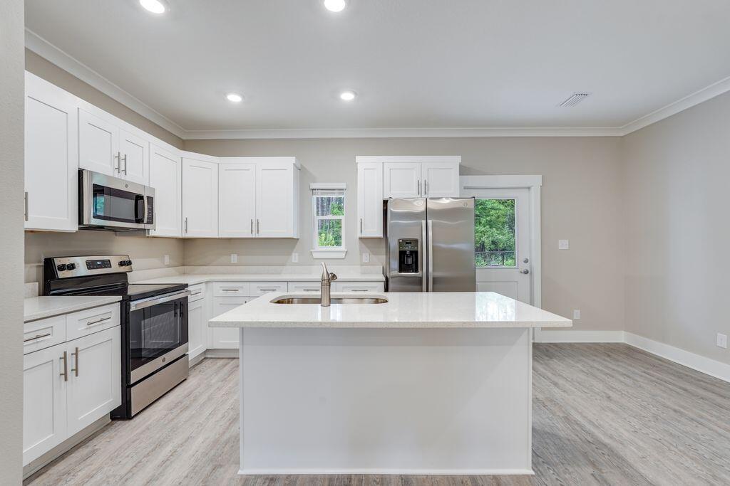 91 Date Palm Lane Freeport, FL 32439 - Photo 4 of 17 a kitchen with stainless steel appliances granite countertop a sink stove and refrigerator