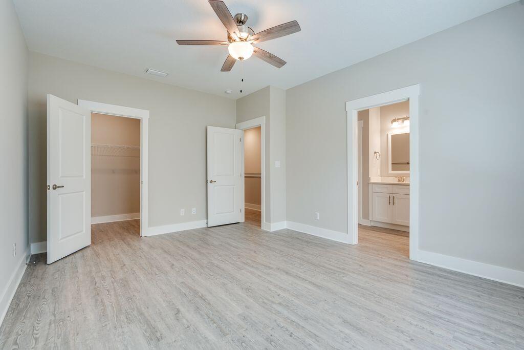 91 Date Palm Lane Freeport, FL 32439 - Photo 10 of 17 an empty room with wooden floor and a ceiling fan