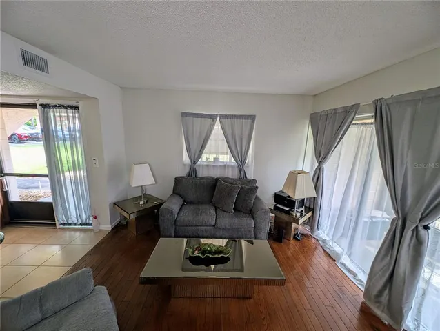 a living room with furniture and a wooden floor