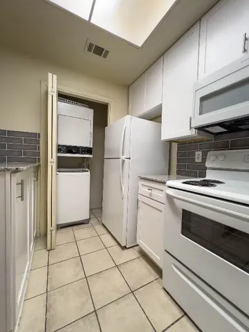 a kitchen with white cabinets and white appliances