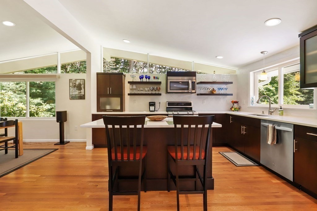 430 Heald Road Carlisle, MA 01741 - Photo 14 of 42 a kitchen with stainless steel appliances granite countertop a stove top oven a sink a dining table and chairs