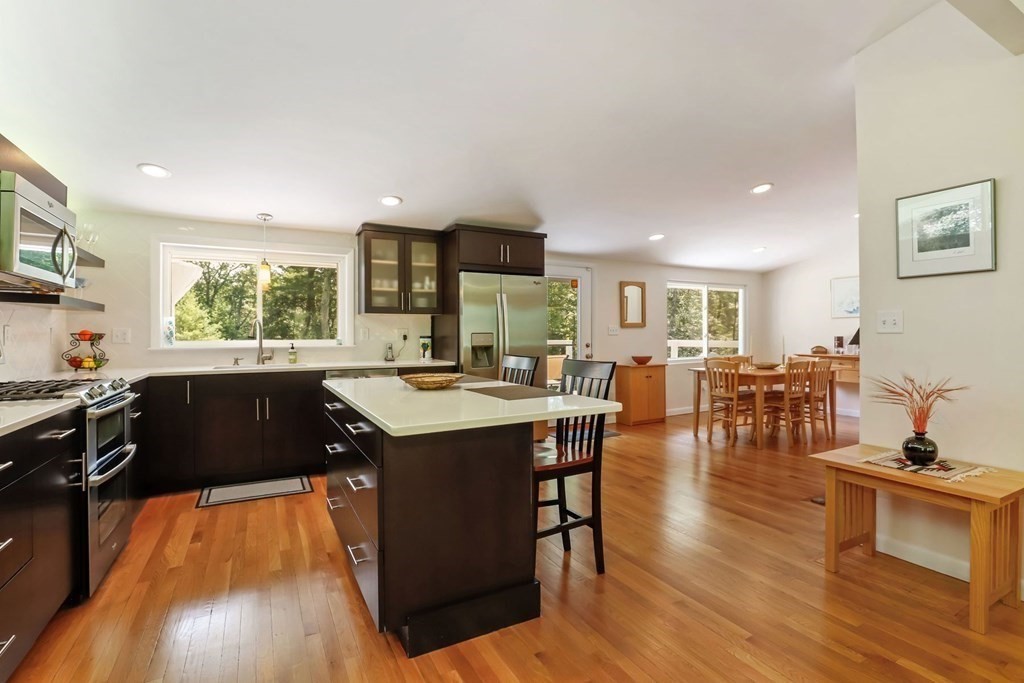 430 Heald Road Carlisle, MA 01741 - Photo 18 of 42 a kitchen with a counter top space a sink a stove a dining table and chairs