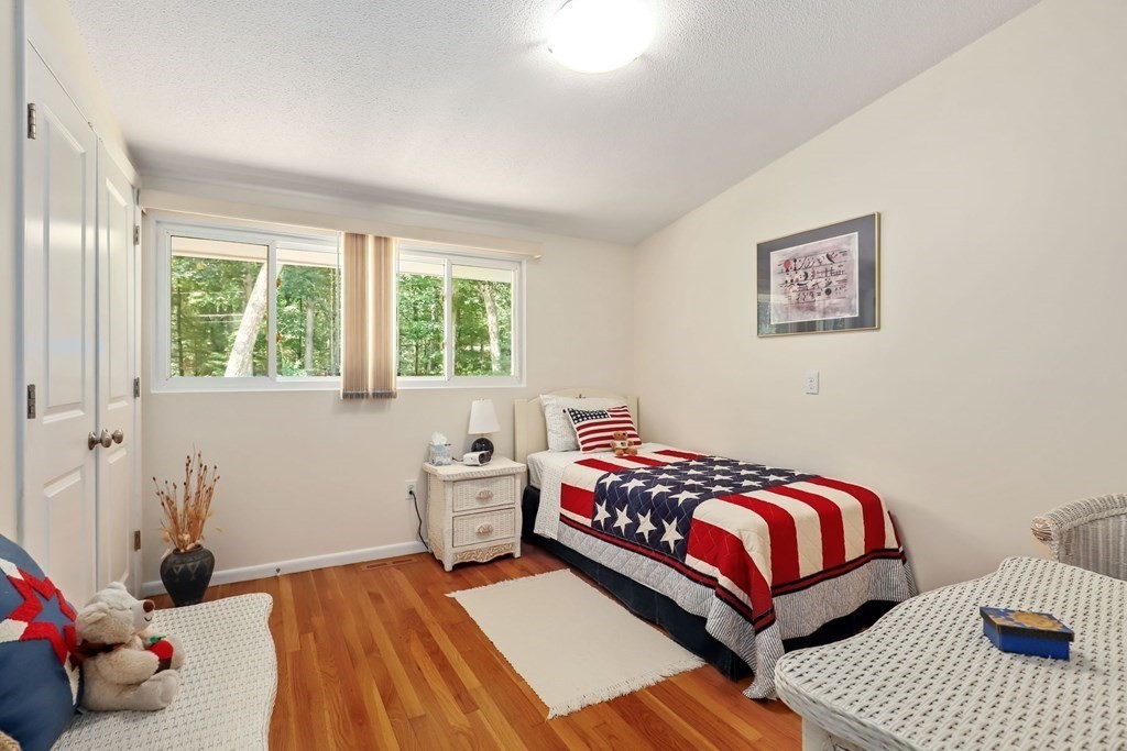 430 Heald Road Carlisle, MA 01741 - Photo 25 of 42 a bedroom with a bed and wooden floor