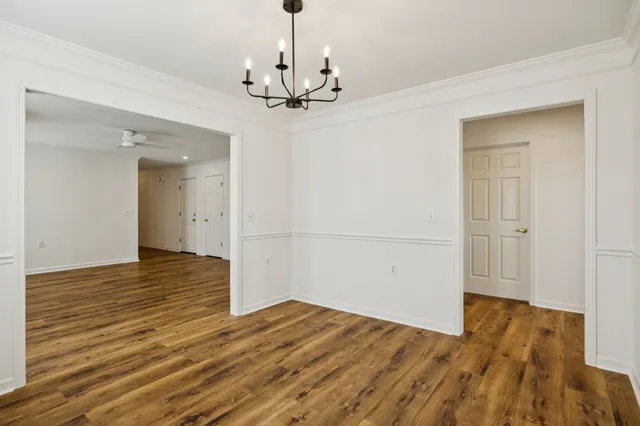 a view of empty room with wooden floor and ceiling fan