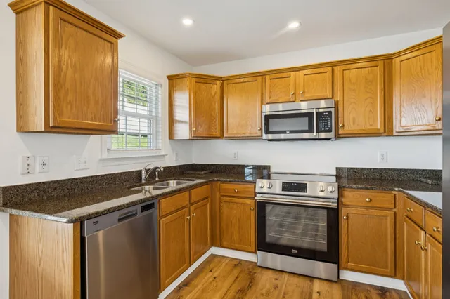 a kitchen with stainless steel appliances granite countertop a sink stove and microwave
