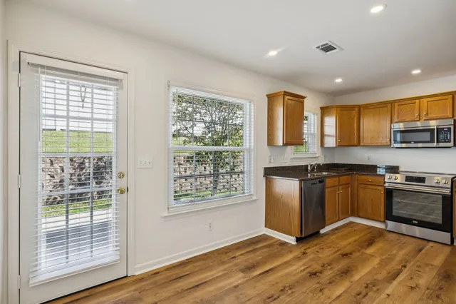 a kitchen with stainless steel appliances granite countertop a stove a sink and a refrigerator