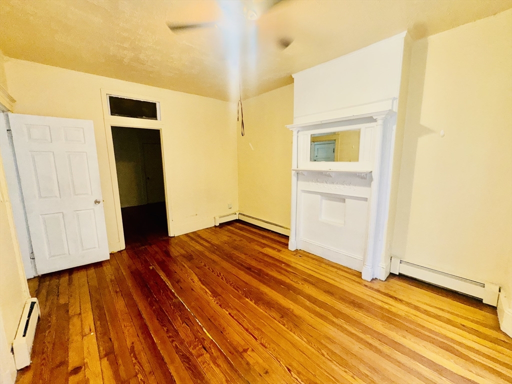 20 South Huntington Avenue, Unit 1 Boston, MA 02130 - Photo 6 of 9 a bedroom with a bed and wooden floor