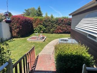 301 Freeman Road, Unit 23 Central Point, OR 97502 - Photo 26 of 32 Ramp to back yard featuring inground sprinklers on timer.