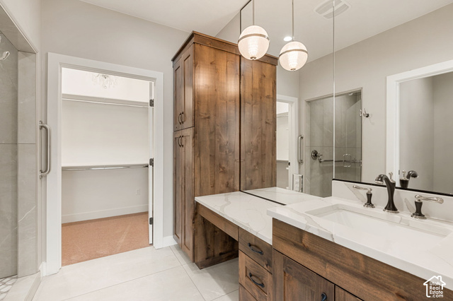 1192 East Ashdown Road Cedar City, UT 84721 - Photo 58 of 96 Dual vanity with white countertop and integrated sinks, wood-finish cabinetry, and globe pendant lighting